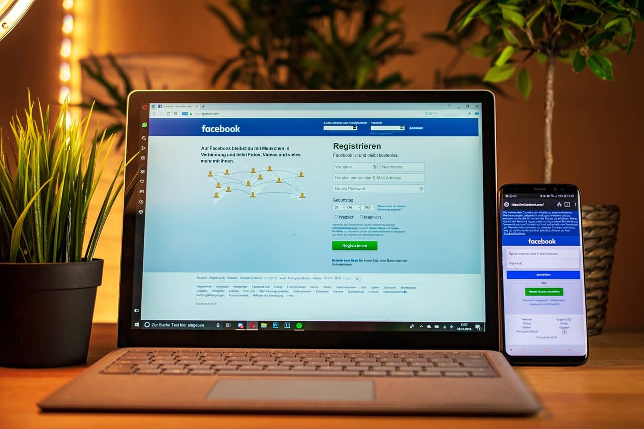 Facebook login page displayed on a laptop and smartphone, representing Meta Ads management